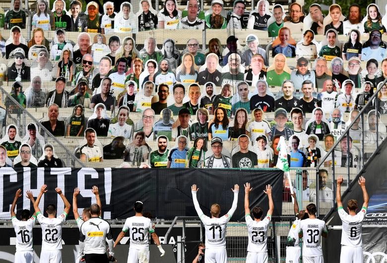 Borussia Moenchengladbach players celebrate after their Bundesliga match against FC Union Berlin in front of cardboards photos of fans displayed in the stands at Borussia Park in Germany. Martin Meissner/Pool via REUTERS  